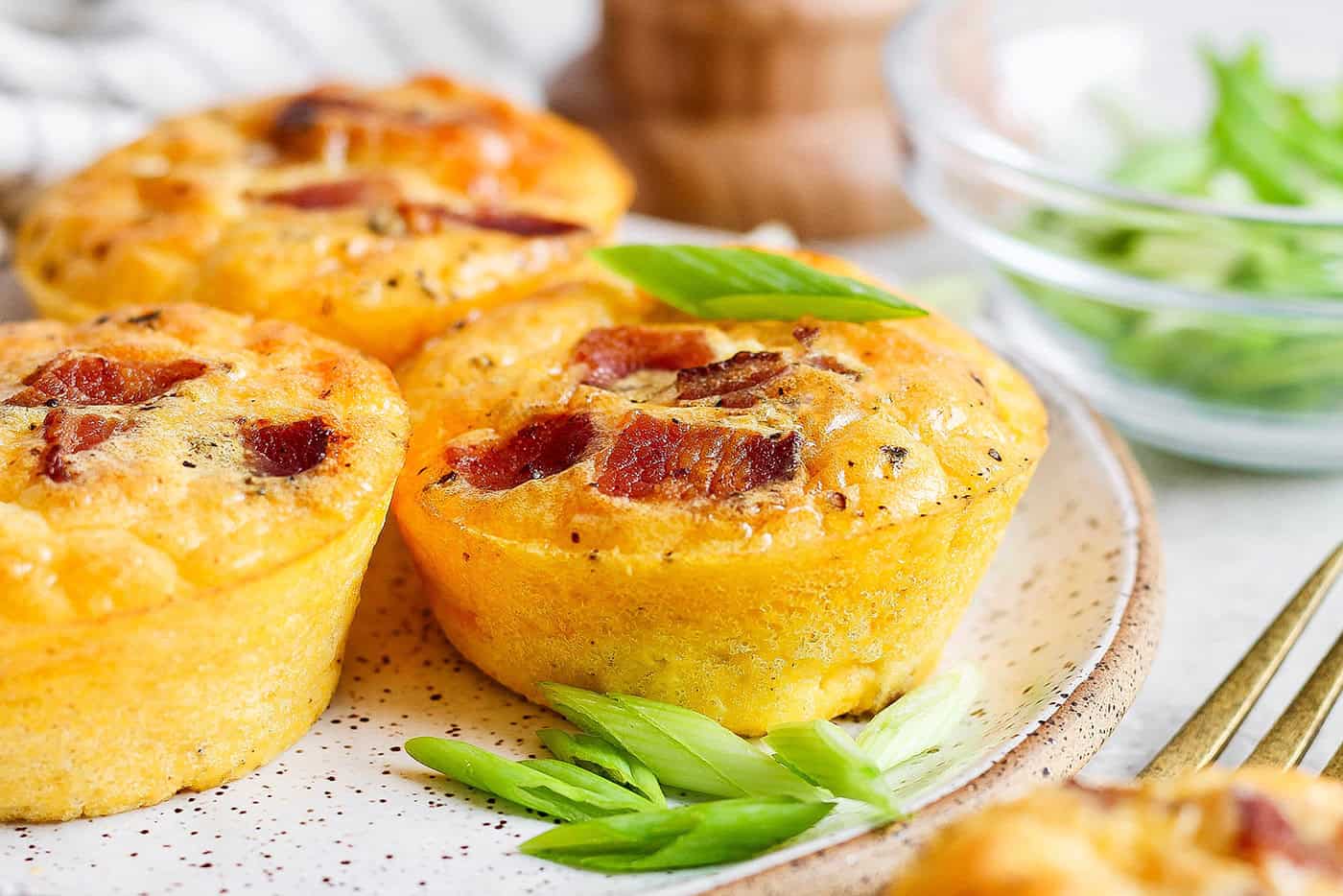 3 cottage cheese egg bites on plate with fresh herbs for garnish