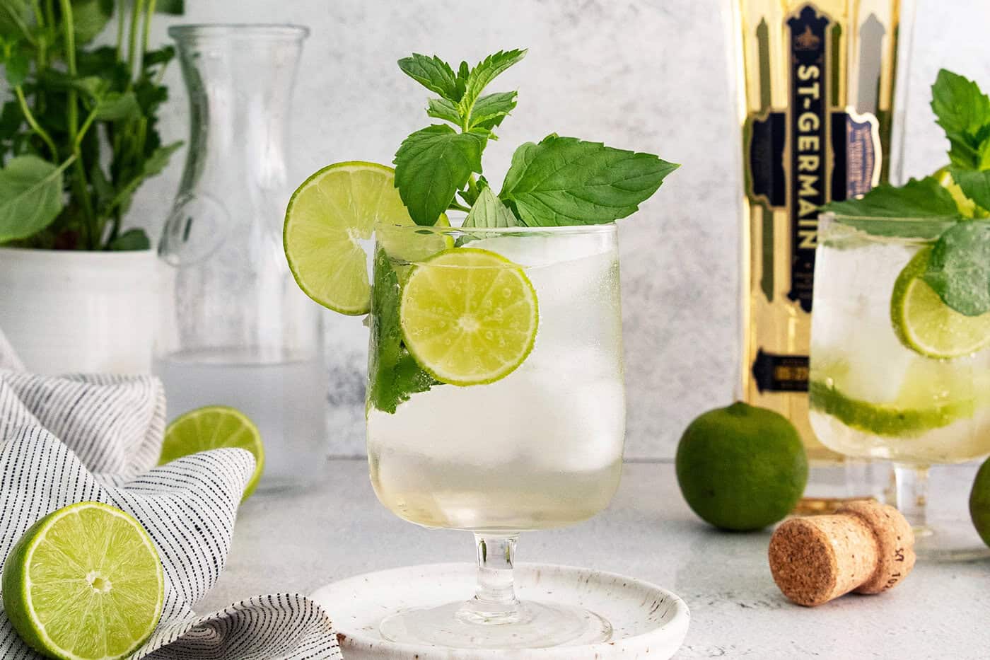 Hugo spritz cocktail in glass with sprig of mint and lime wheels