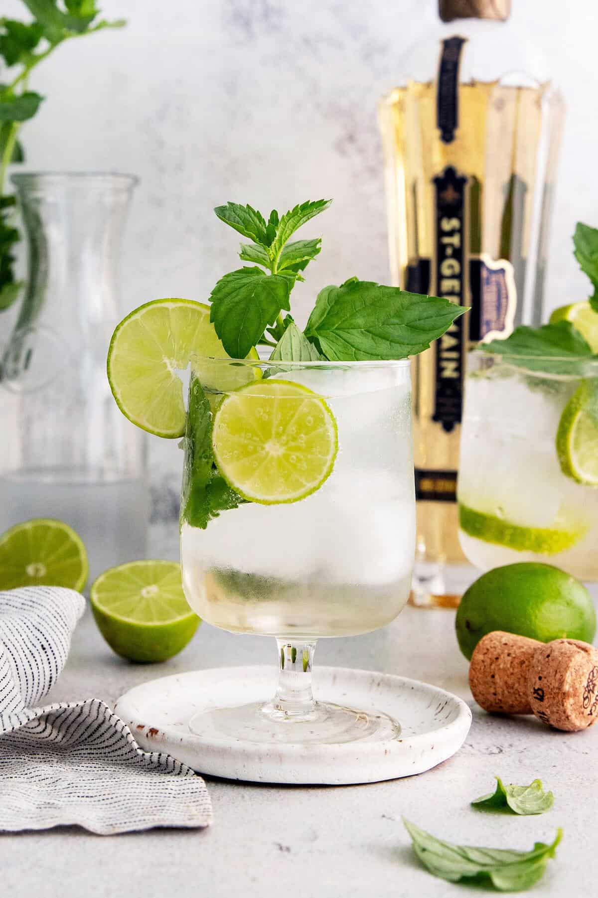Hugo spritz cocktail in glass with sprig of mint and lime wheels