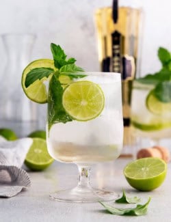 Hugo spritz cocktail in glass with lime wheels and sprigs of mint