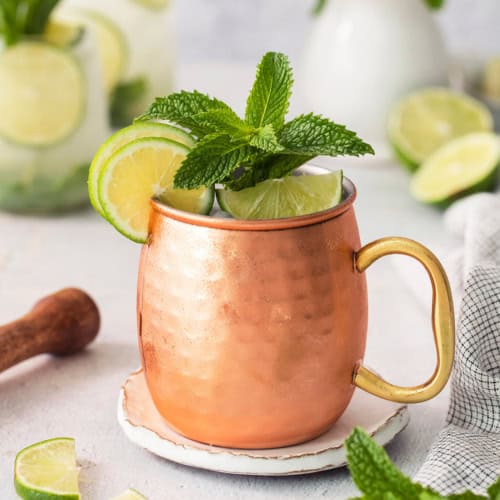 Copper mug with Moscow mule mocktail garnished with fresh lime and mint