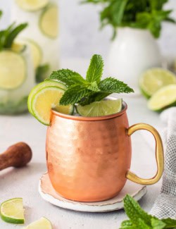 Copper mug with Moscow mule mocktail garnished with fresh lime and mint