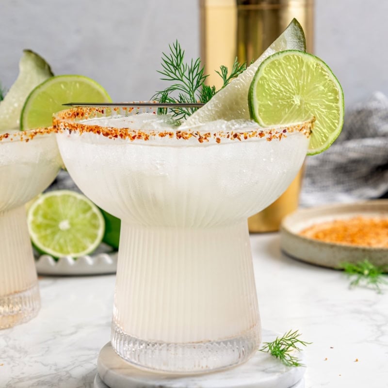 Pickle margarita garnished with pickle spear, dill, and lime wheel