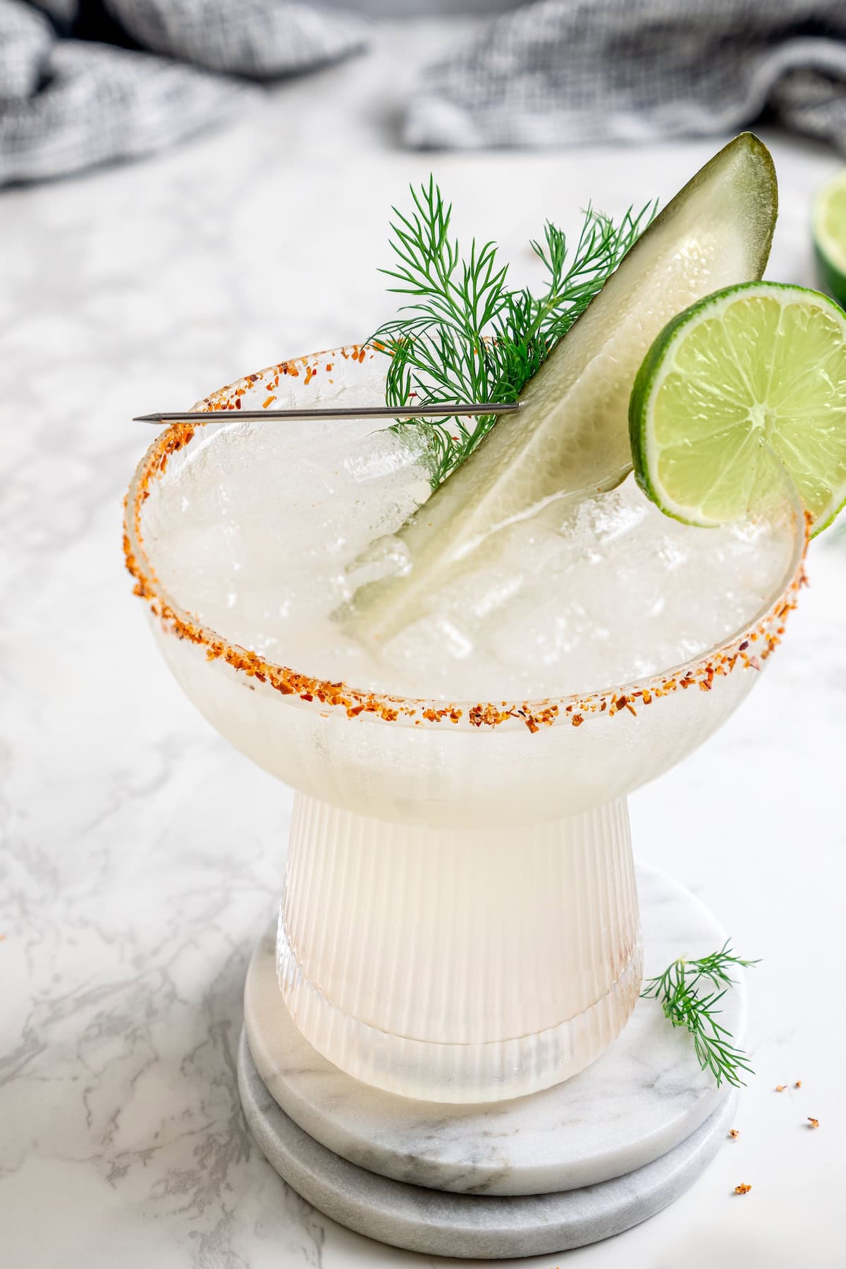 Pickle margarita garnished with pickle spear, dill, and lime wheel