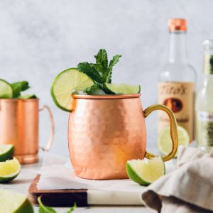 Moscow mule in copper mug with sprig of mint and fresh lime