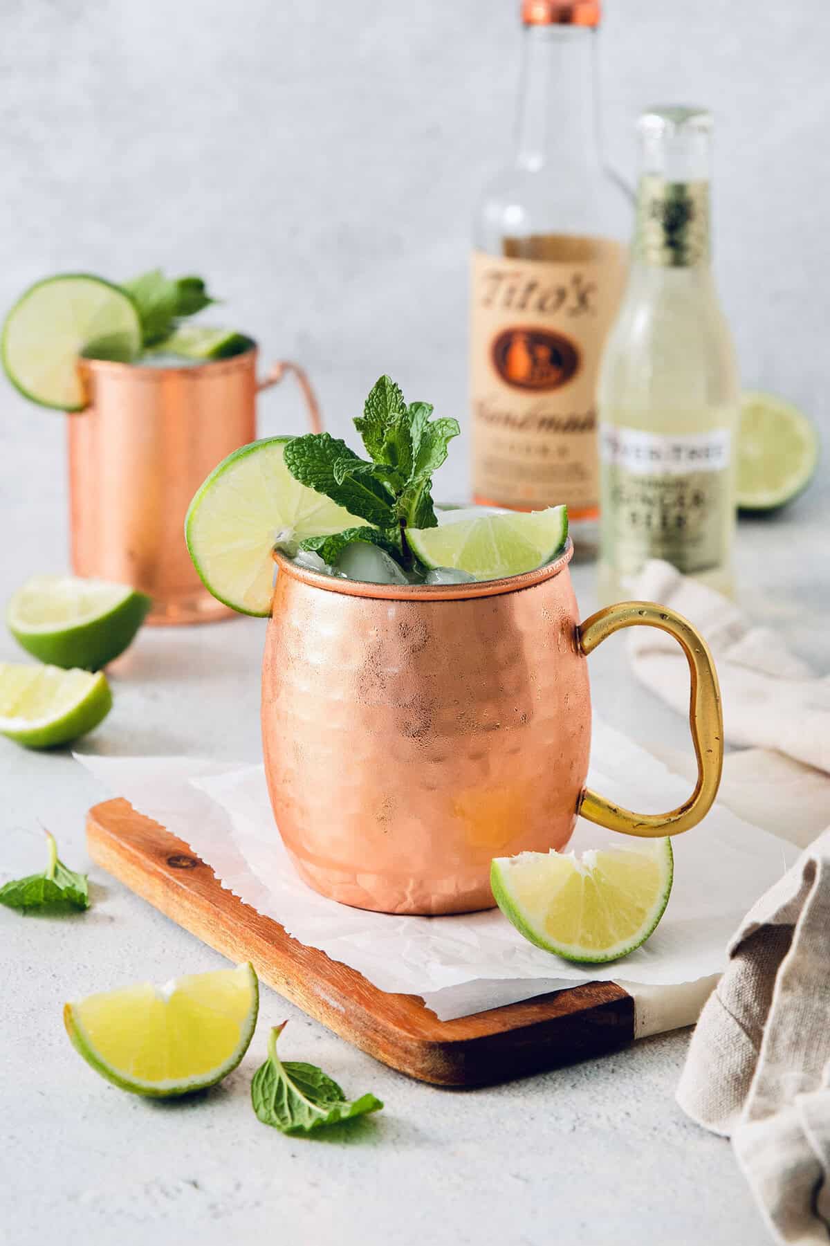 Moscow mule in copper mug with sprig of mint and lime wheel on rim