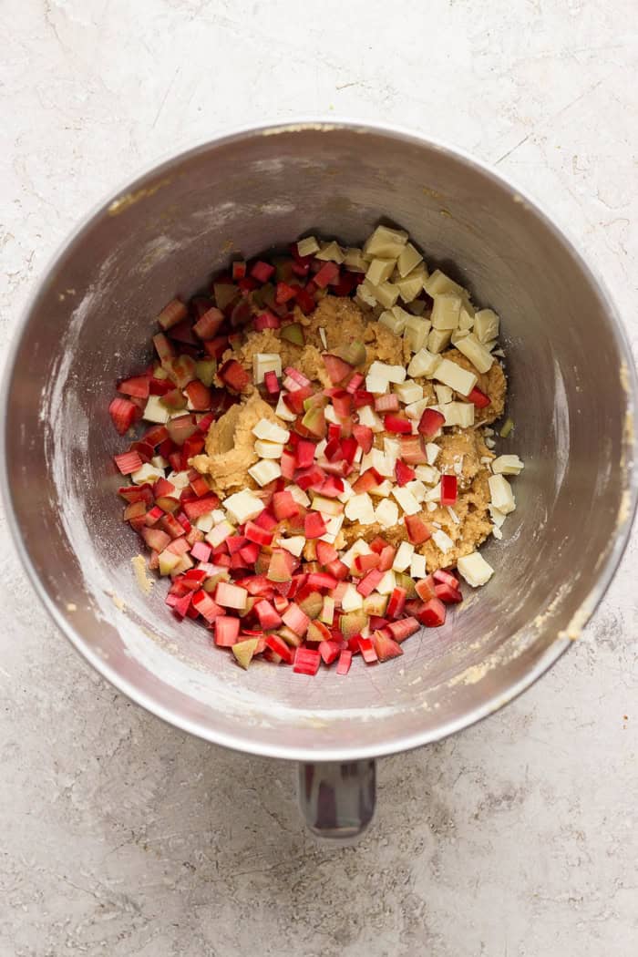 Overhead view of rhubarb and white chocolate added to bowl of cookie dough