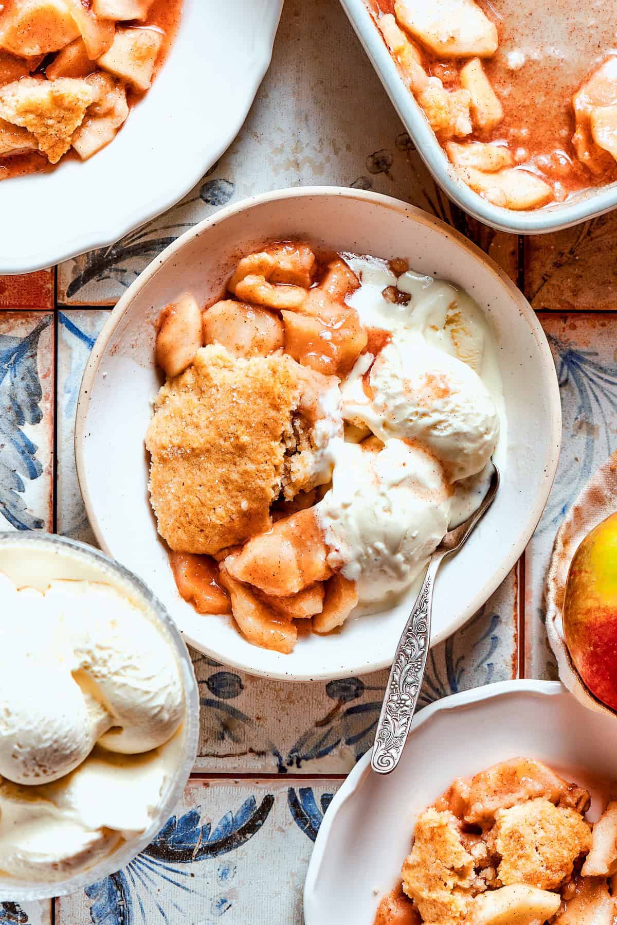 Overhead view of apple cobbler served in bowl with vanilla ice cream
