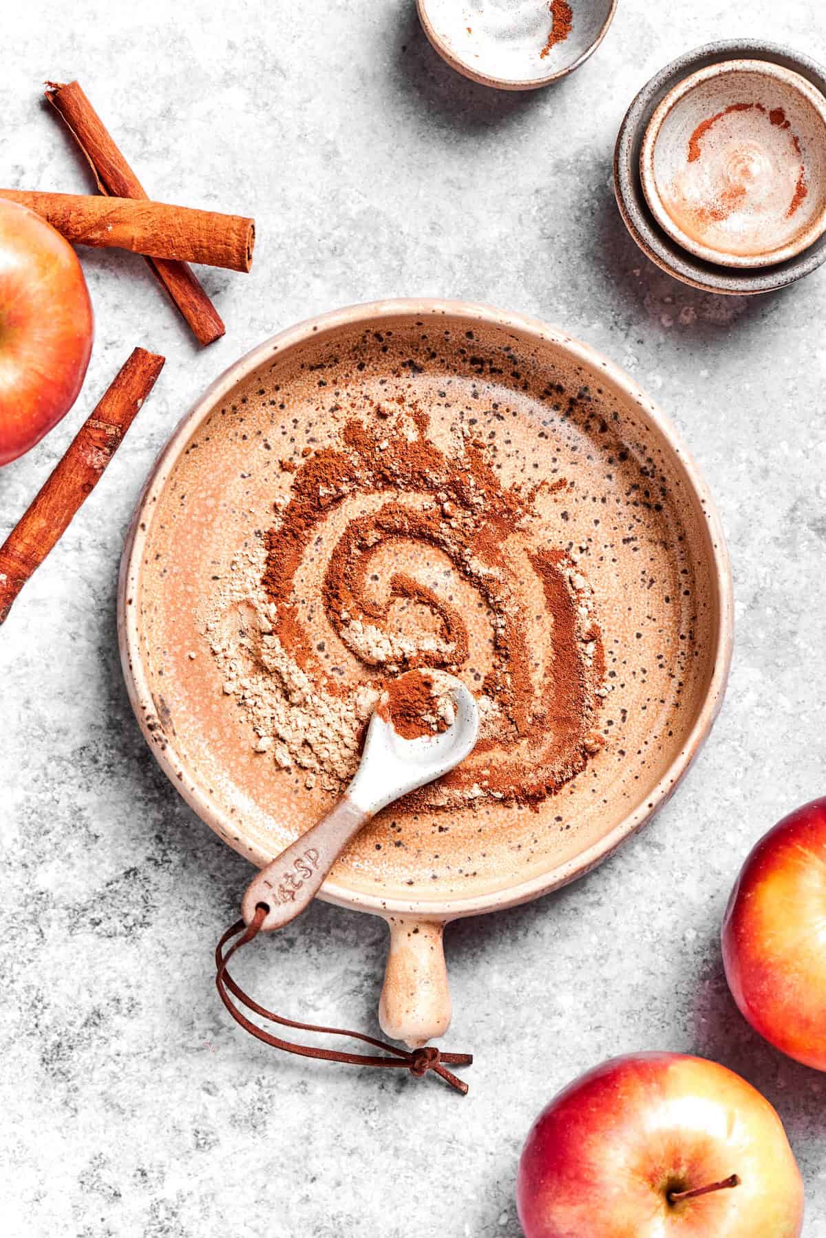 Overhead view of apple pie spice mixture in bowl with measuring spoon