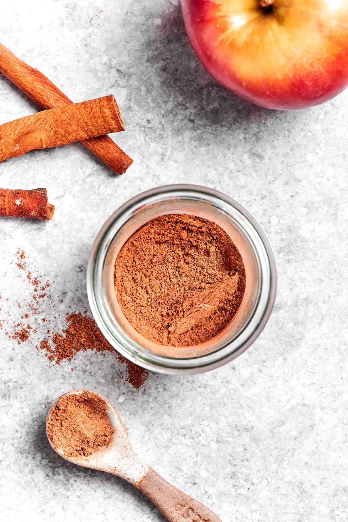 Overhead view of apple pie spice in jar and on measuring spoon