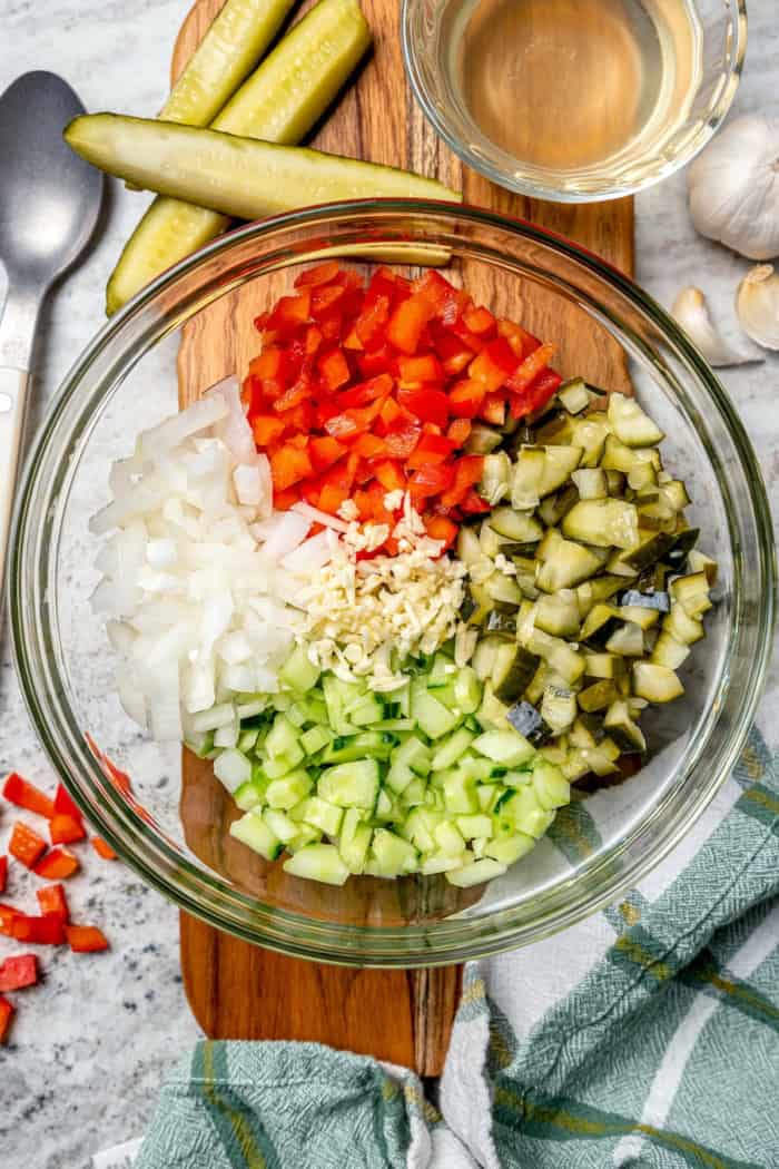 Overhead view of ingredients for pickle de gallo in glass bowl