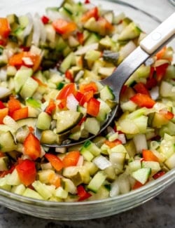 a spoon in a bowl of pickle de gallo
