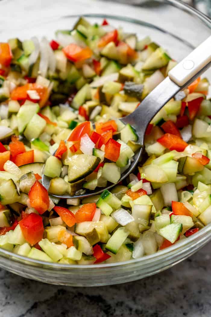 a spoon in a bowl of pickle de gallo