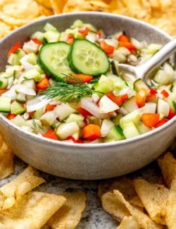 a bowl of pickle salsa with a bunch of potato chips