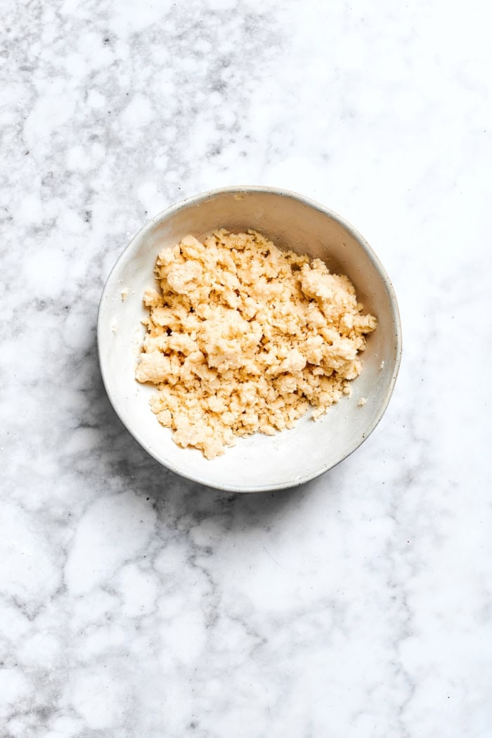 Buttery shortbread is layered with rhubarb custard to create these irresistible Rhubarb Custard Bars. Don't skip the cream cheese topping! Overhead view of crust mixture for rhubarb custard bars in bowl