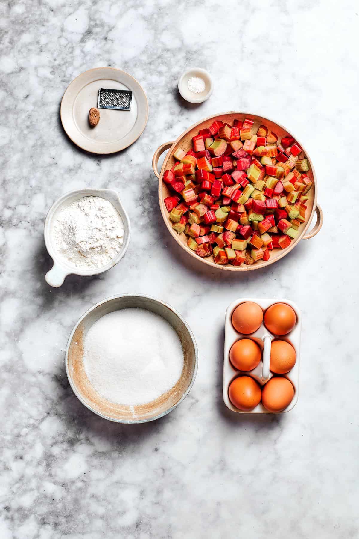 Buttery shortbread is layered with rhubarb custard to create these irresistible Rhubarb Custard Bars. Don't skip the cream cheese topping! Overhead view of ingredients for rhubarb custard bar filling