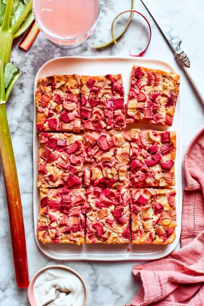 Buttery shortbread is layered with rhubarb custard to create these irresistible Rhubarb Custard Bars. Don't skip the cream cheese topping! Overhead view of rhubarb custard bars cut into rectangles