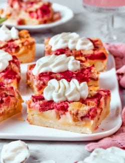 rhubarb custard bars with cream cheese topping, on a white platter