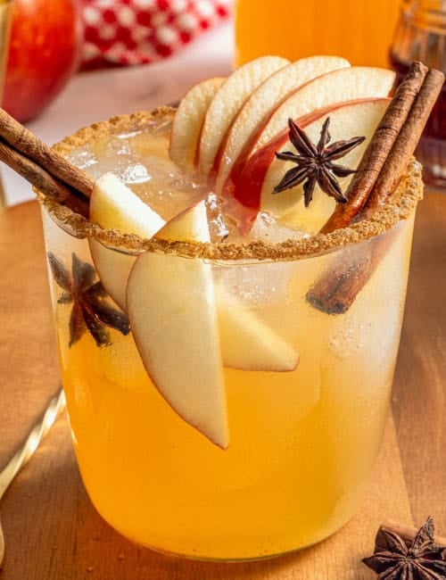 a glass of apple cider margarita with fresh apple slices