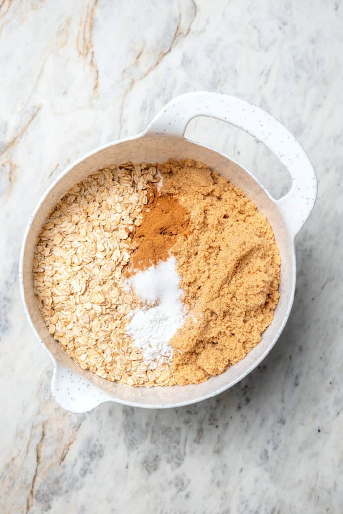 A brown sugar oat crumble mixture doubles as a crust and a topping for these easy Apple Pie Bars. The perfect fall treat for a crowd! Dry ingredients for apple crumb mixture in mixing bowl.