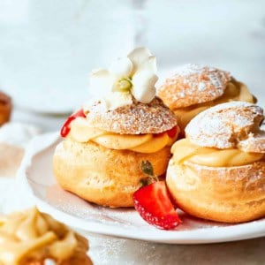 mini cream puffs filled with vanilla pastry cream and fresh strawberry sauce, and dusted with powdered sugar