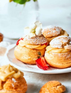 mini cream puffs filled with vanilla pastry cream and fresh strawberry sauce, and dusted with powdered sugar