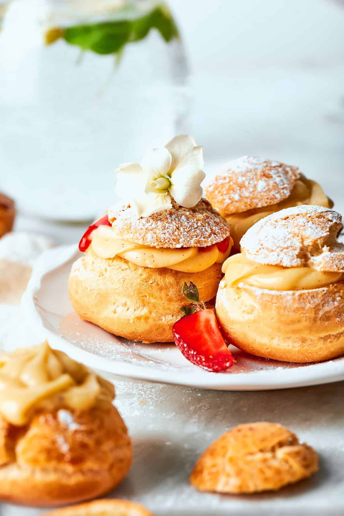 mini cream puffs filled with vanilla pastry cream and fresh strawberry sauce, and dusted with powdered sugar