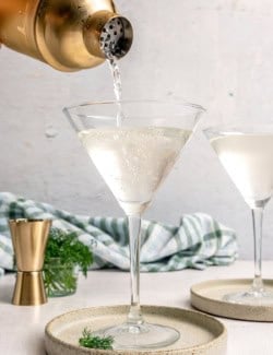 Pouring pickle martini into glass