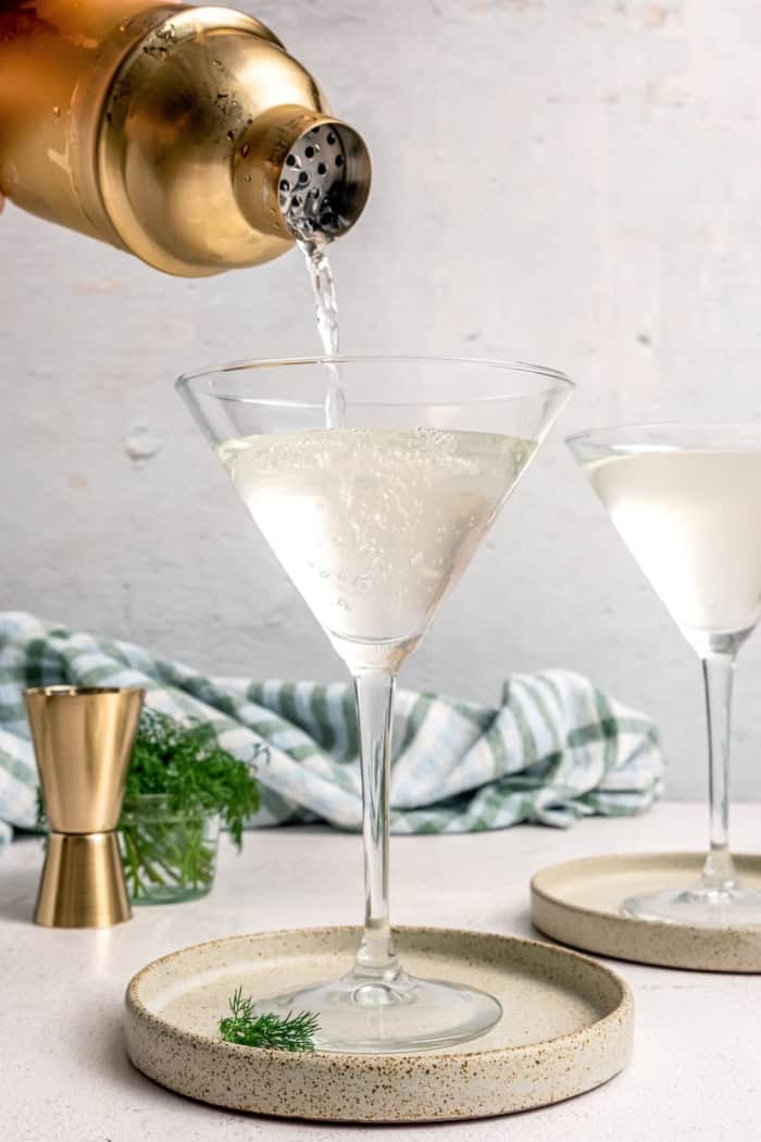 Inspired by the classic dirty martini recipe, pickle brine adds a pop of bold, briny flavor to this savory and smooth pickle martini. Pouring pickle martini into glass