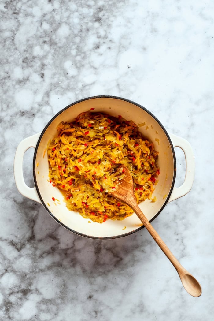 Overhead view of pickle relish in pot with wooden spoon