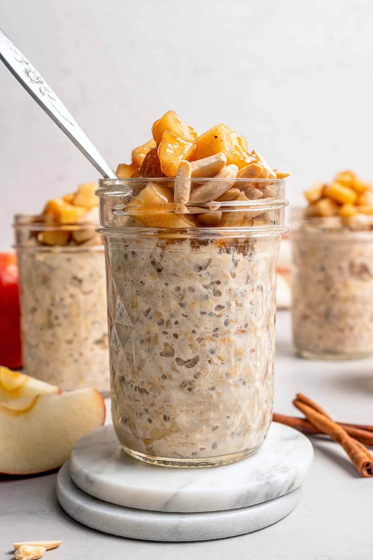 jars of apple overnight oats with sauteed apples and slivered almonds on top