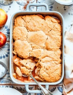 a white rectangular baking dish with baked Apple Cobbler