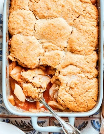 overhead photo of a white rectangular baking dish with baked Apple Cobbler