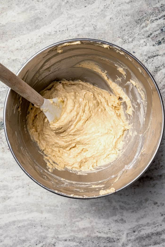 Batter for apple fritter bread in bowl with rubber spatula.