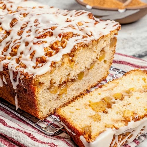 glazed apple fritter bread, sliced to show the fresh apple filling inside