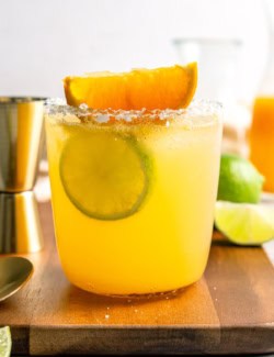 Margarita mocktail rimmed with salt and garnished with lime wheel and orange wedge