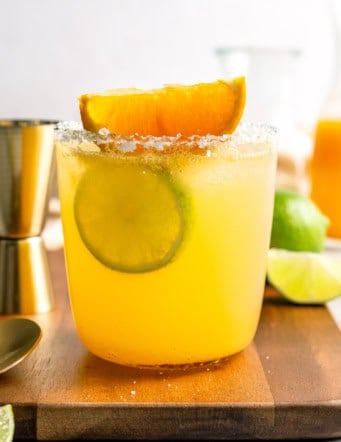 Margarita mocktail rimmed with salt and garnished with lime wheel and orange wedge