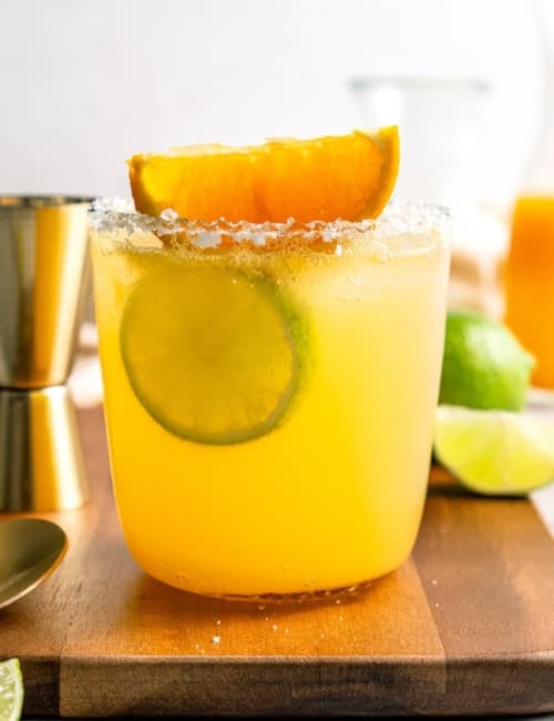 Margarita mocktail rimmed with salt and garnished with lime wheel and orange wedge
