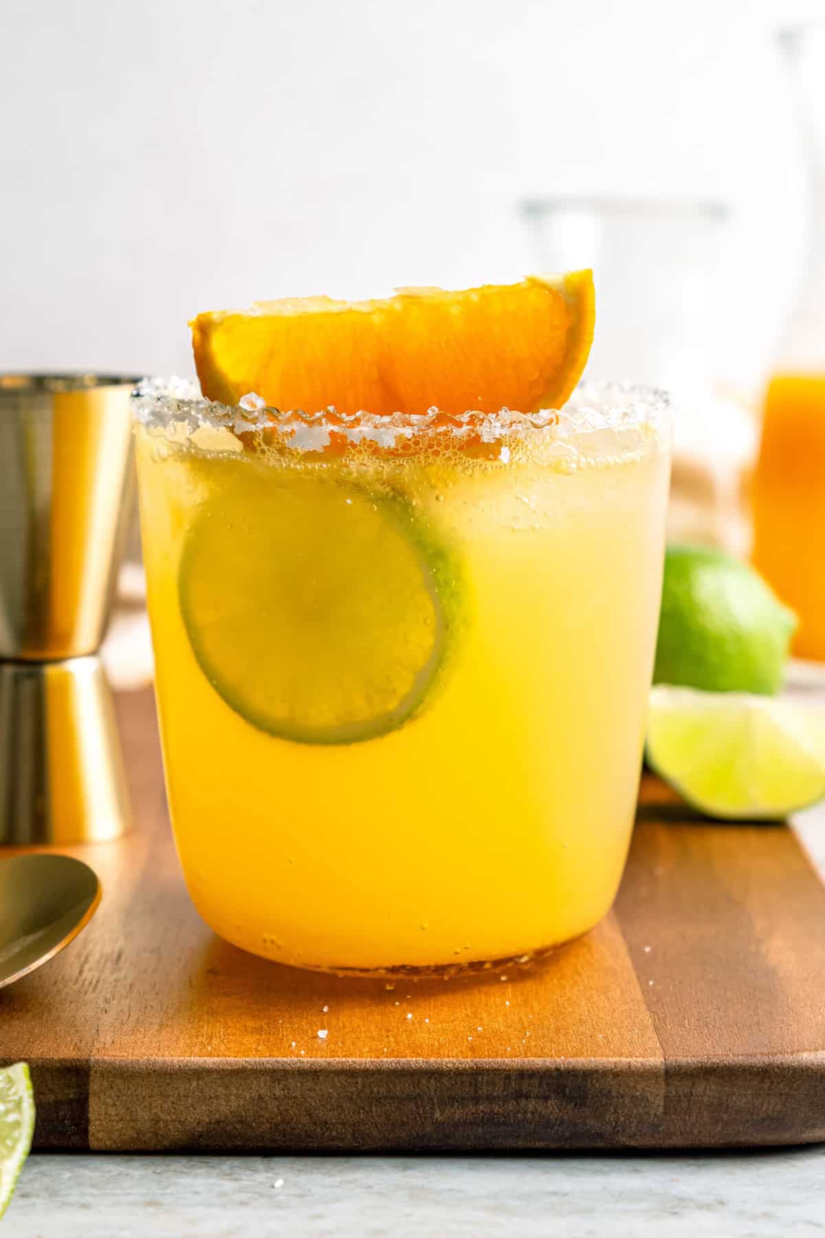 Deliciously tart and refreshing, this fizzy Margarita Mocktail has the bright citrus flavor of the real-deal, in non-alcoholic form! Margarita mocktail rimmed with salt and garnished with lime wheel and orange wedge