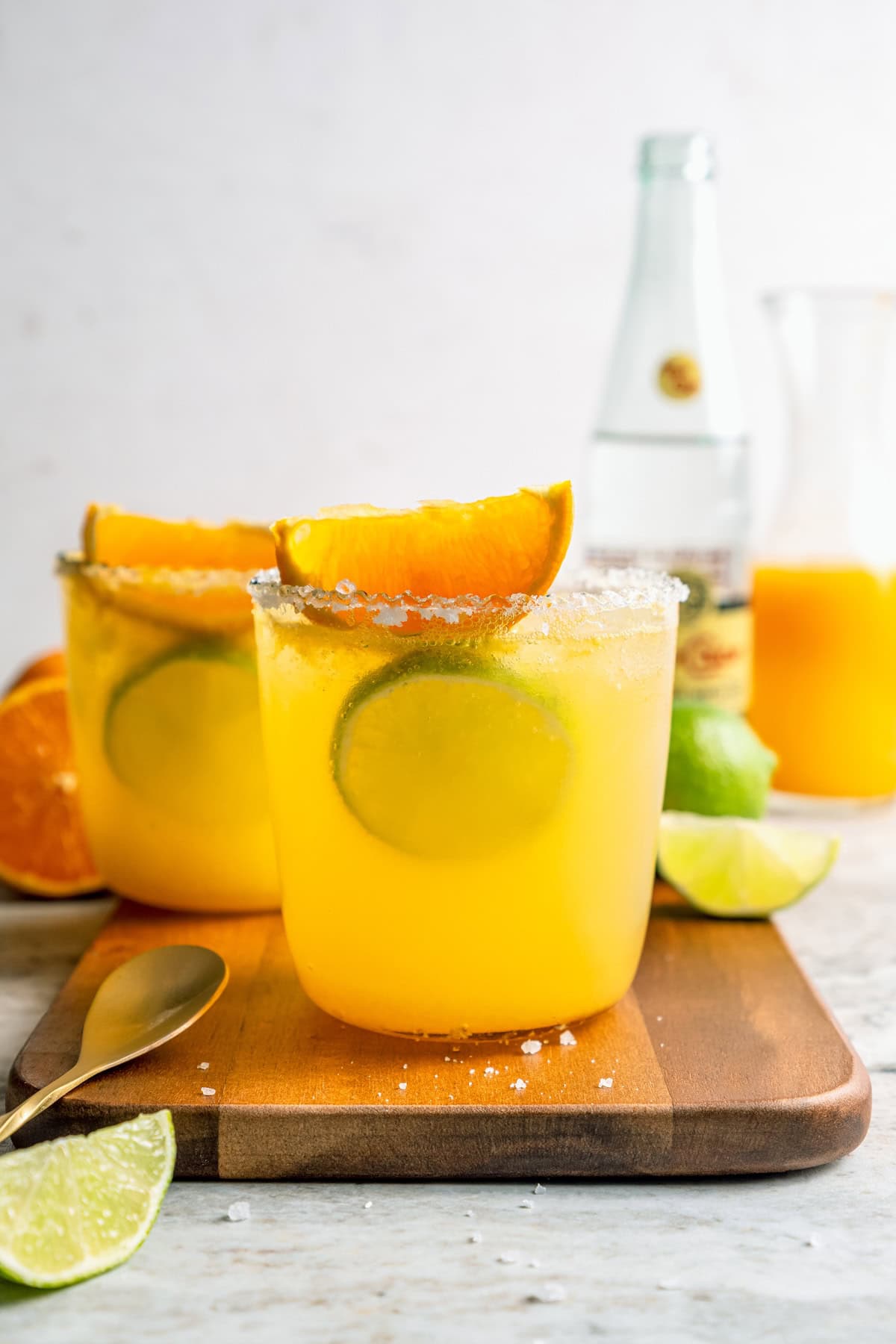 Deliciously tart and refreshing, this fizzy Margarita Mocktail has the bright citrus flavor of the real-deal, in non-alcoholic form! Two margarita mocktails in glasses rimmed with salt