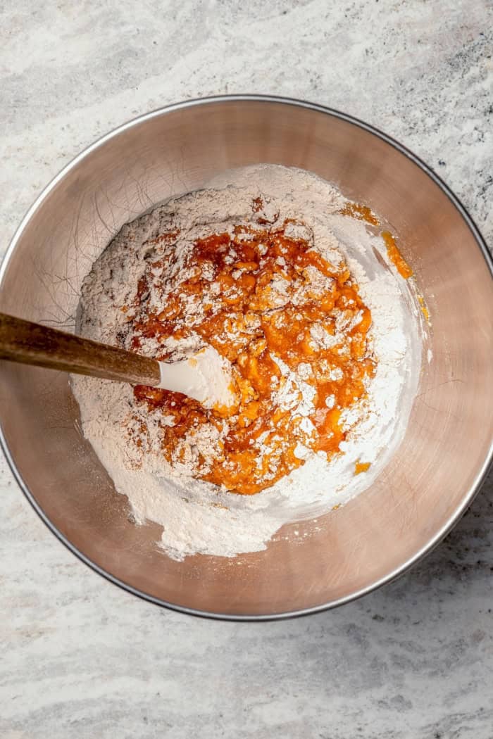 Soft, moist, and chewy, these Pumpkin Chocolate Chip Cookies are the perfect sweet treat for fall! Pumpkin pie spice adds warm, cozy flavor. Stirring dry and wet ingredients in mixing bowl.