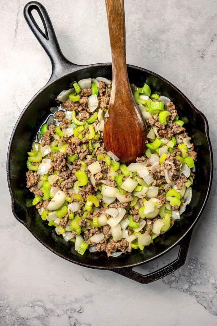 Sausage, celery, and onion cooking in skillet.