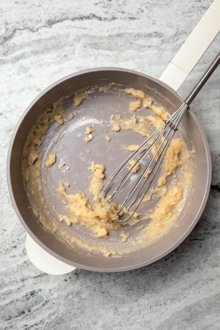 Whisking roux in saucepan.