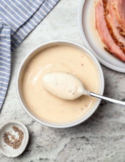 Bowl of ham gravy with spoon.