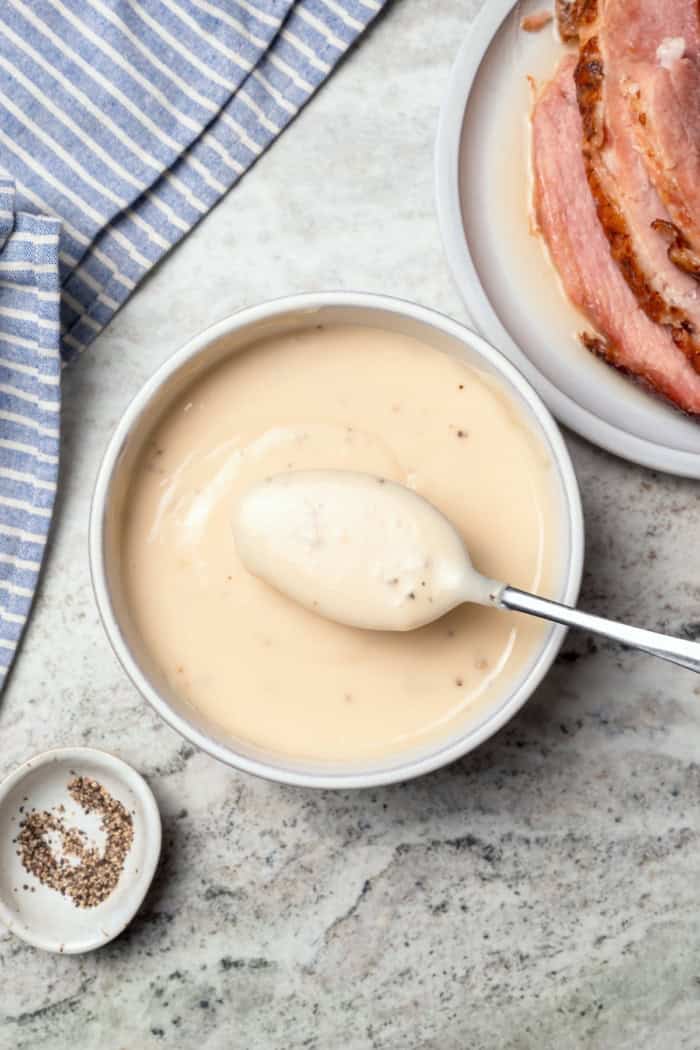Bowl of ham gravy with spoon.