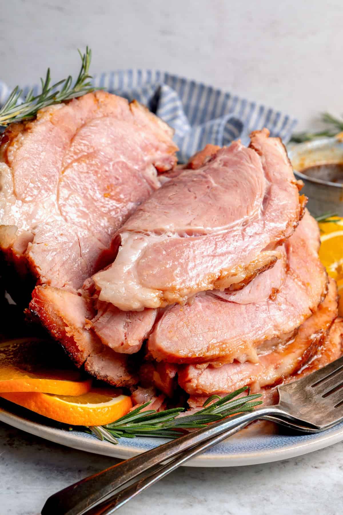 This Orange-Brown Sugar Ham Glaze is sweet and citrusy, but mustard, balsamic vinegar and warm spices add depth too. Easy and delicious! Sliced ham with orange-brown sugar ham glaze.