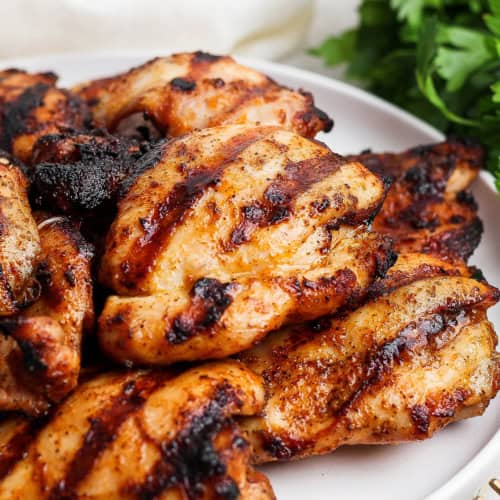 Grilled chicken thighs on platter.