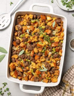 overhead photo of stuffing with sausage in a rectangular white baking dish