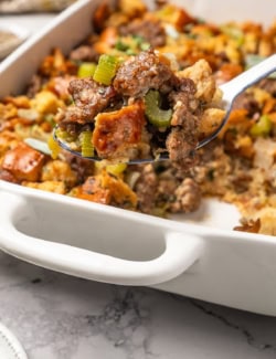 a serving spoon full of sausage stuffing