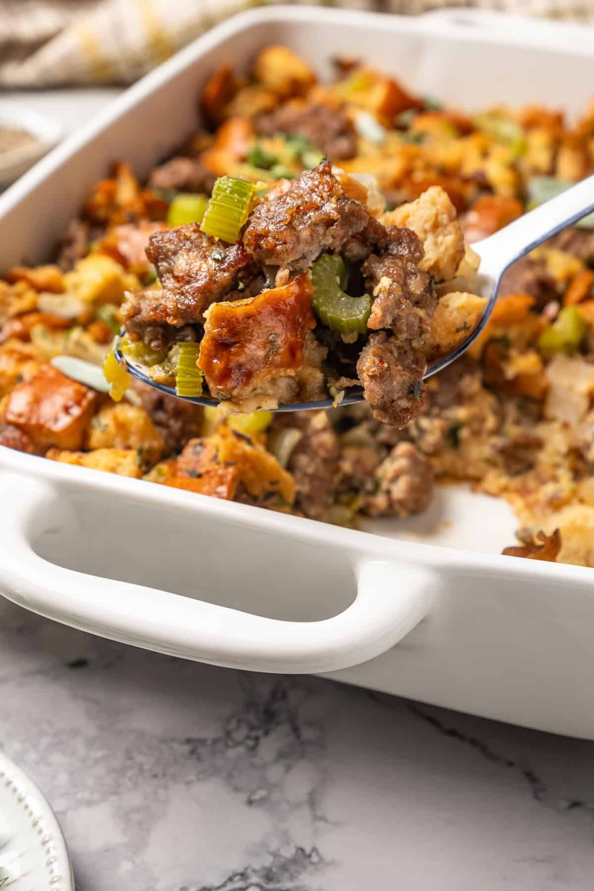 a serving spoon full of sausage stuffing